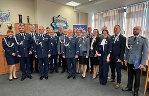 Policjanci odznaczeni medalami pozują razem do wspólnego zdjęcia.