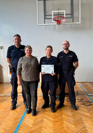 Policjanci i kobieta pozują do zdjęcia.