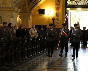 Poczet sztandarowy Policji wchodzi do kościoła.
