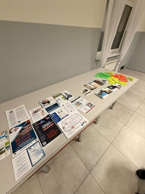 Materiały profilaktyczno - informacyjne oraz elementy odblaskowe ułożone na stole.
