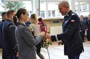 Policjant wręcza policjantce różę.