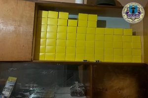 W segmencie typu "meblościanka", w górnej szafce są pudełka z zawartością nielegalnych papierosów.