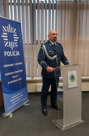 Policjant przy mównicy.
