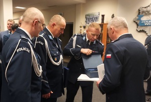 Policjanci składają życzenia odchodzącemu inspektorowi Robertowi Krawczykowi.