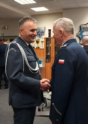 Dyrektor Zakładu Karnego składa komendantowi życzenia. Podają sobie dłonie.
