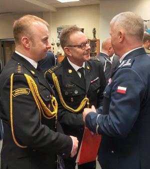 Komendanci straży pożarnej składają życzenia odchodzącemu komendantowi.