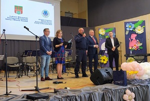 Na scenie stoi kilka osób, do mikrofonu mówi komendant Policji.