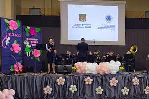 Na scenie gra orkiestra policyjna.