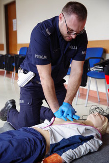 Policjant na fantomie robi resuscytację.