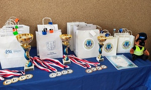 Na stole stoją puchary, medale i nagrody dla zwycięzców.