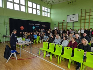 Policjantka podczas spotkania w szkole prezentująca walizkę edukacyjną.
