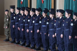 Uczniowie stoją w dwuszeregu podczas uroczystości.