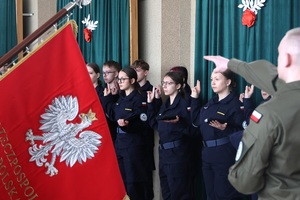 Poczet sztandarowy szkoły, w tle składający ślubowanie.