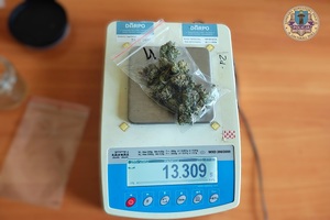Na wadze elektronicznej, w strunowej torebce suszona marihuana.