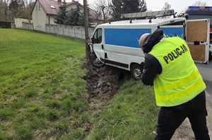 Osoba ma założoną kamizelkę z napisem Policja, robi zdjęcia rozbitemu na słupie pojadzowi.