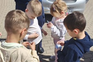 Dzieci oglądają otrzymane odblaski.