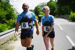 Mężczyzna i kobieta ubrani na sportowo, idą ulicą, uśmiechają się do zdjęcia.