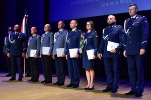 Na scenie policjanci otrzymali akty mianowania, pozują do zdjęcia.