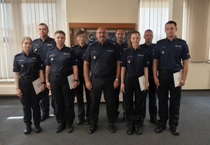 Grupowe zdjęcie awansowanych policjantów z komendantem.