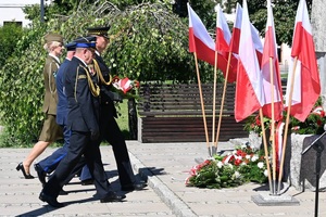 Komendant oraz inni przedstwiciele służb mundurowych, składają kwiaty przed pomnikiem.