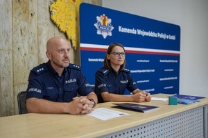Komisja konkursowa - dwoje policjantów siedzi za stołem.