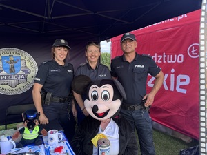 Trzech umundurowanych policjantów z maskotką myszki Micky.