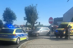 Jezdnia, przejście dla pieszych. Na pasach stoi samochód, obok radiowóz i karetka pogotowia.