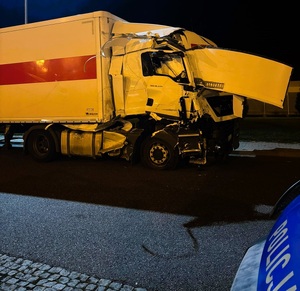 Noc, przy drodze stoi rozbity samochód, ze zniszczoną kabiną kierowcy.