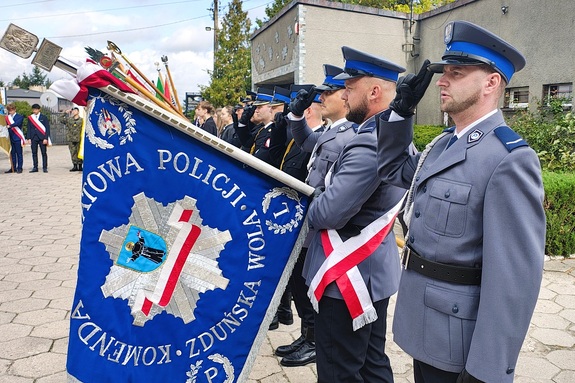 Poczet sztandarowy policjantów salutuje.