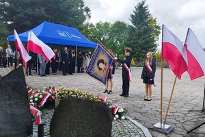 Poczet sztandarowy jednej ze szkół oddaje cześć przed pomnikiem.