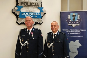Dwaj policjanci stoją obok siebie, pozują do zdjęcia.
