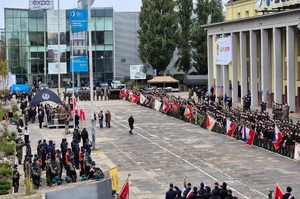 Plac. Zdjęcie z góry. Widać stojące w szeregach pododdziały szkolne.